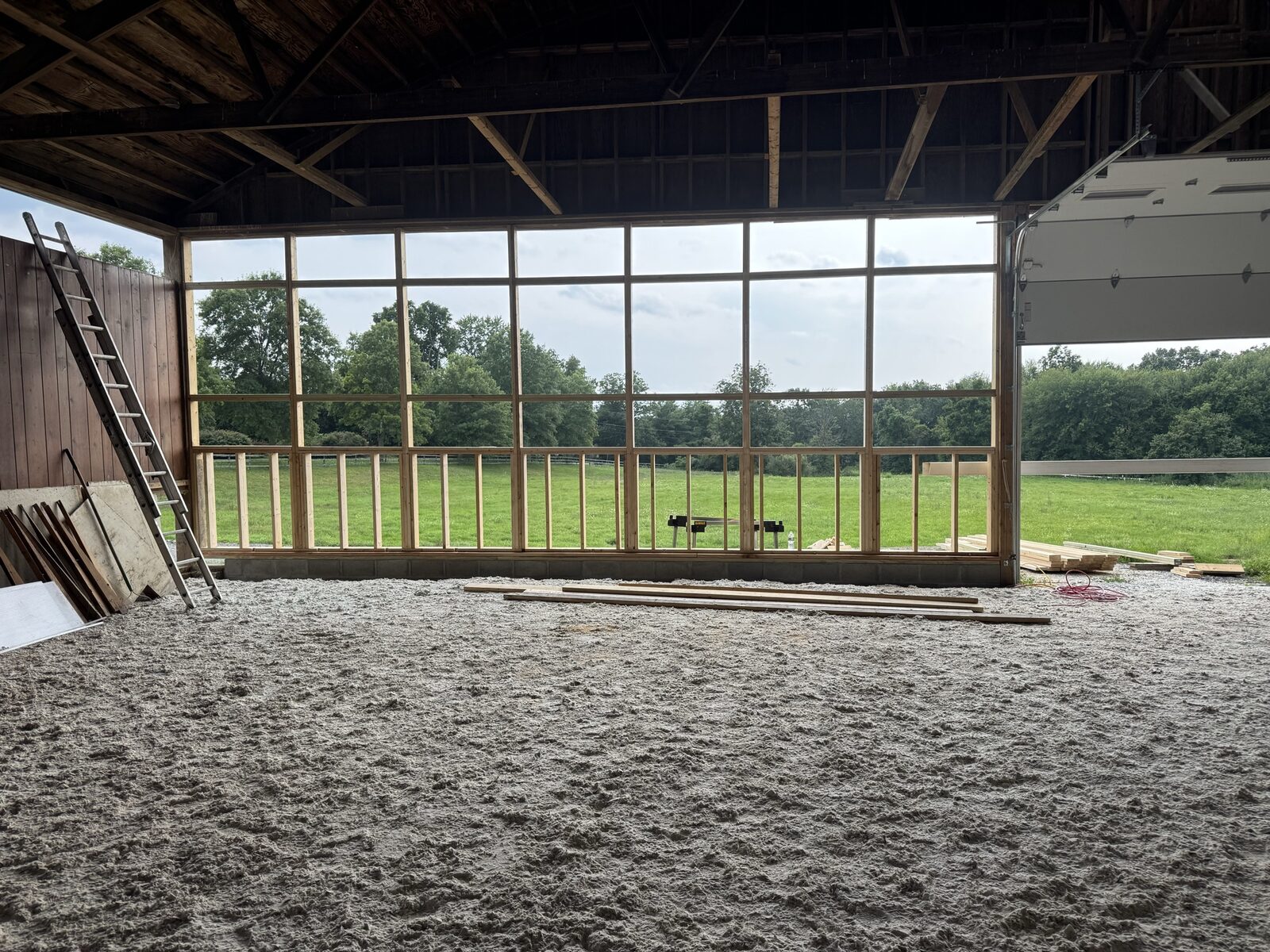 Wide view of a barn conversion with fully framed window wall overlooking a pasture