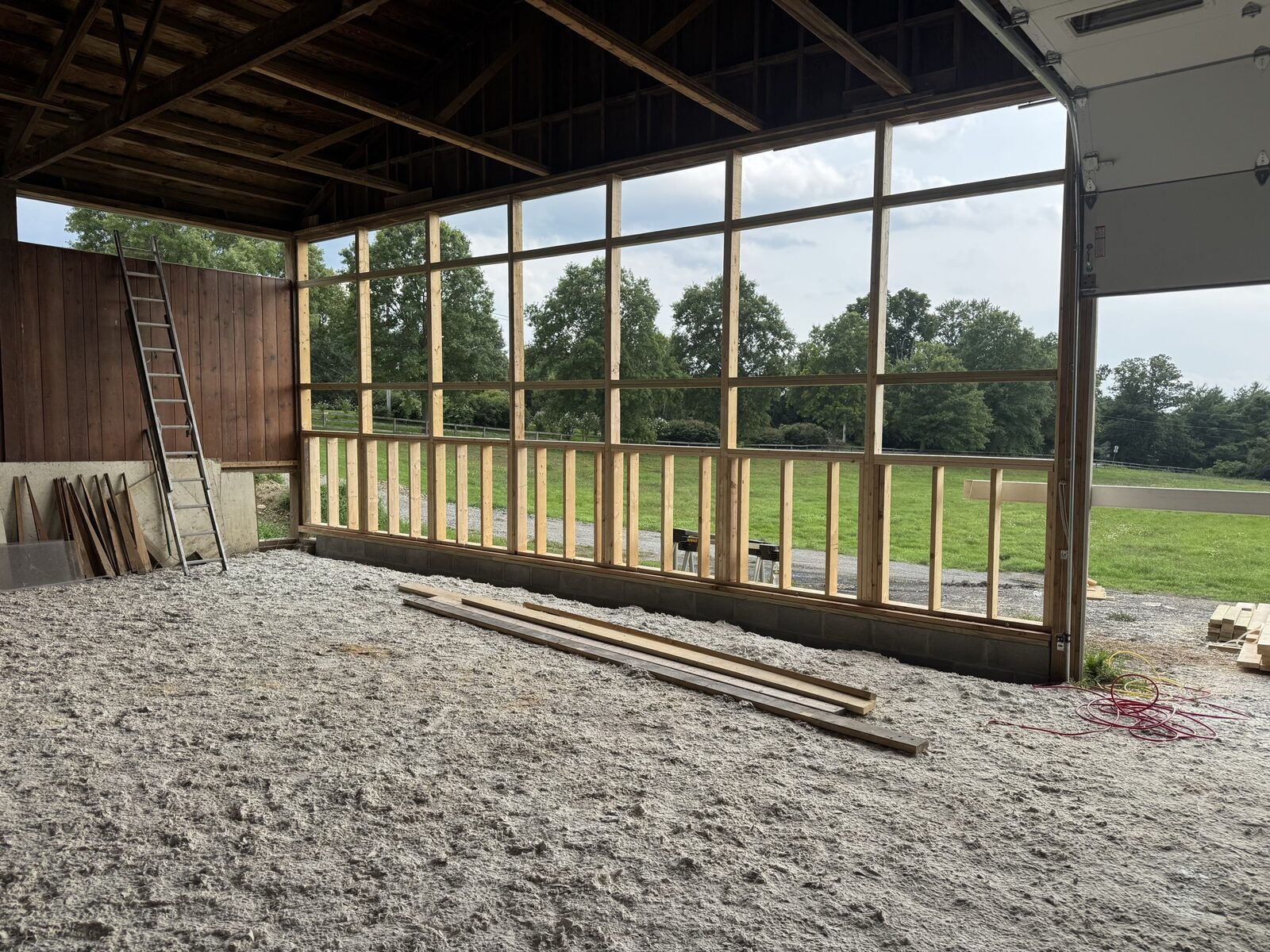 Large barn window wall framed with a view of open farmland
