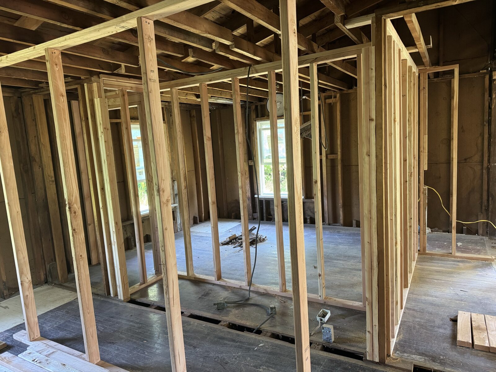 Newly framed interior walls and floor framing inside a home renovation
