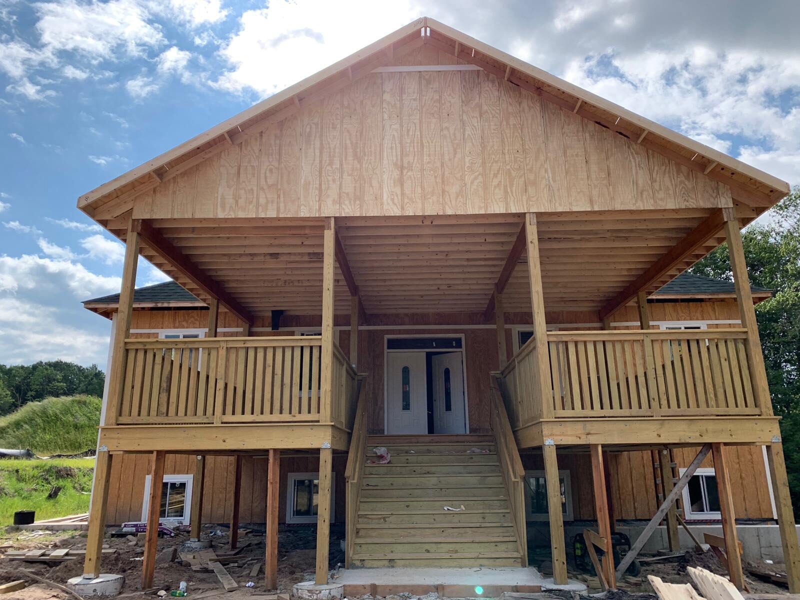 Framed two-story front porch with covered entry and staircase