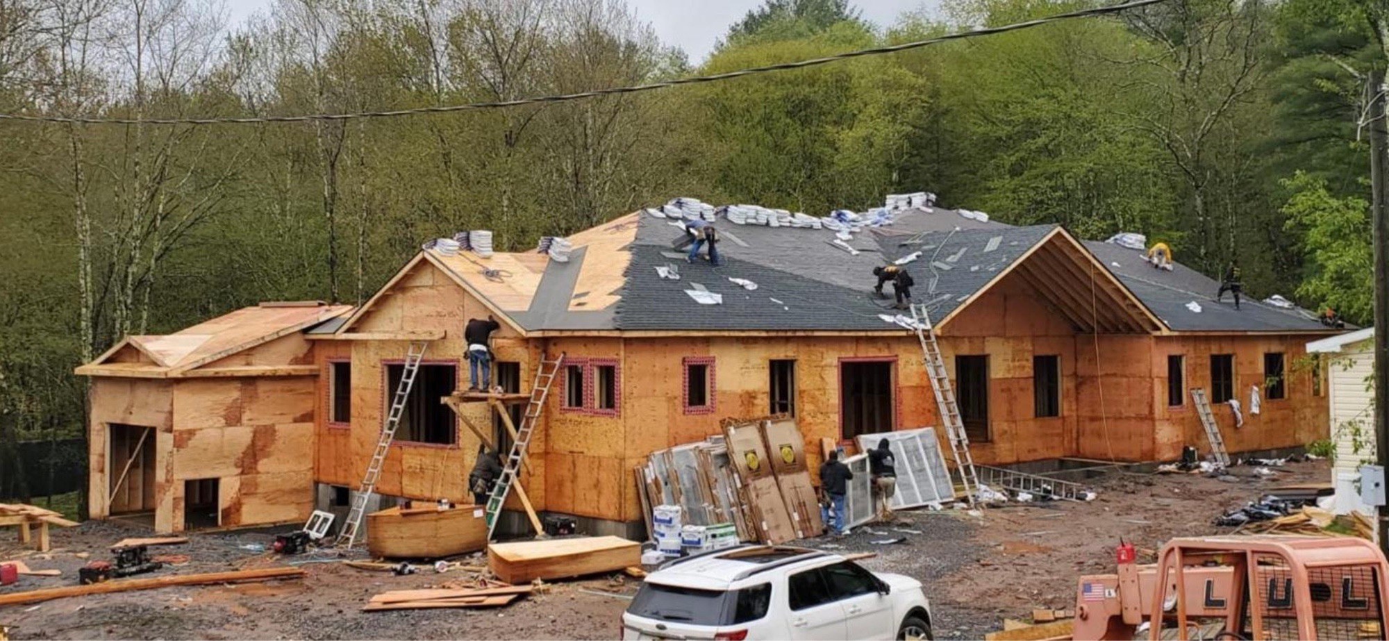 Crew member sweeping up after framing a new interior wall next to an exterior door
