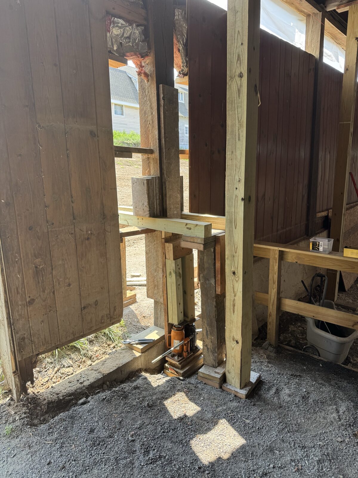 Post and beam being jacked and reinforced during a structural repair