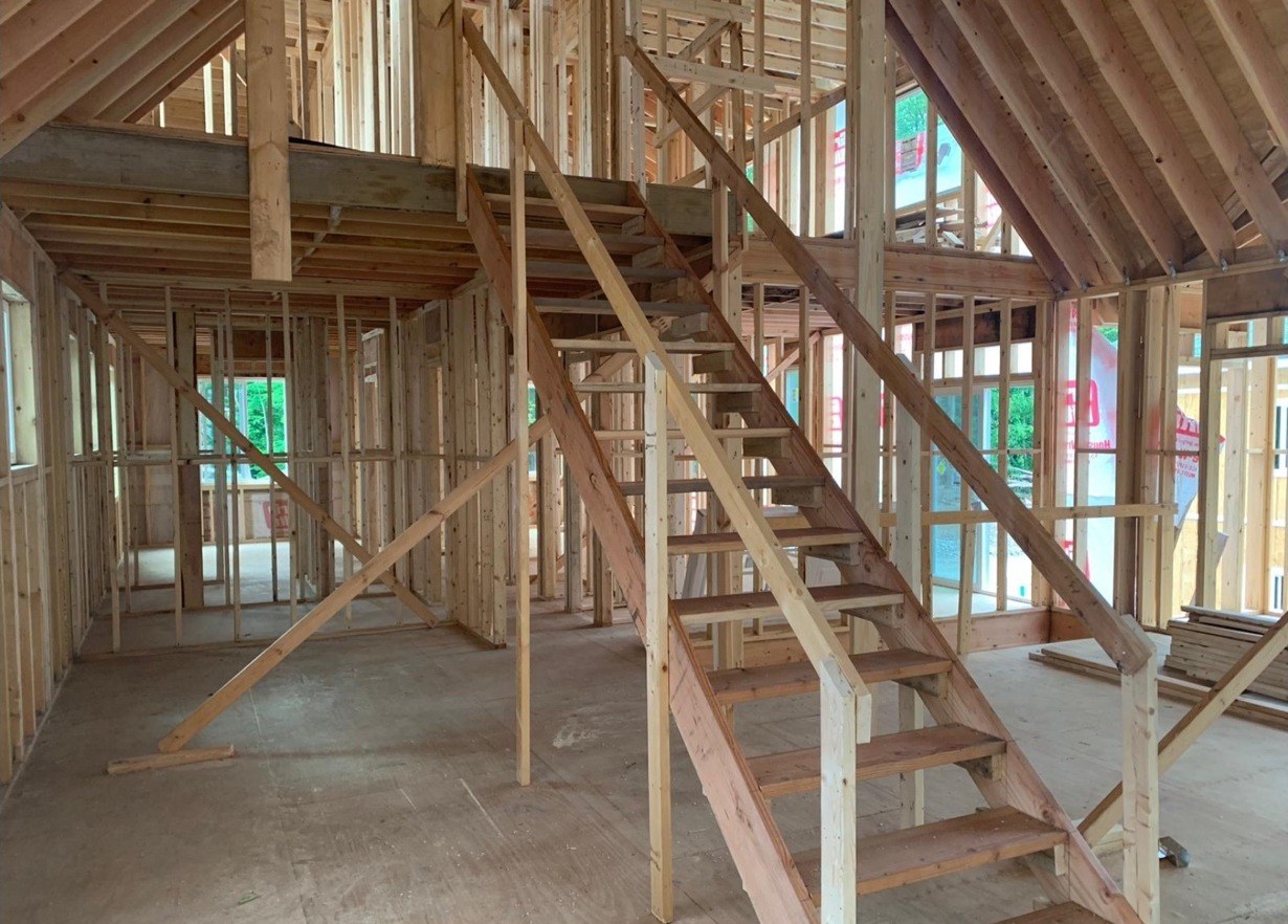Interior wood framing of a vaulted ceiling loft with staircase in a new custom home